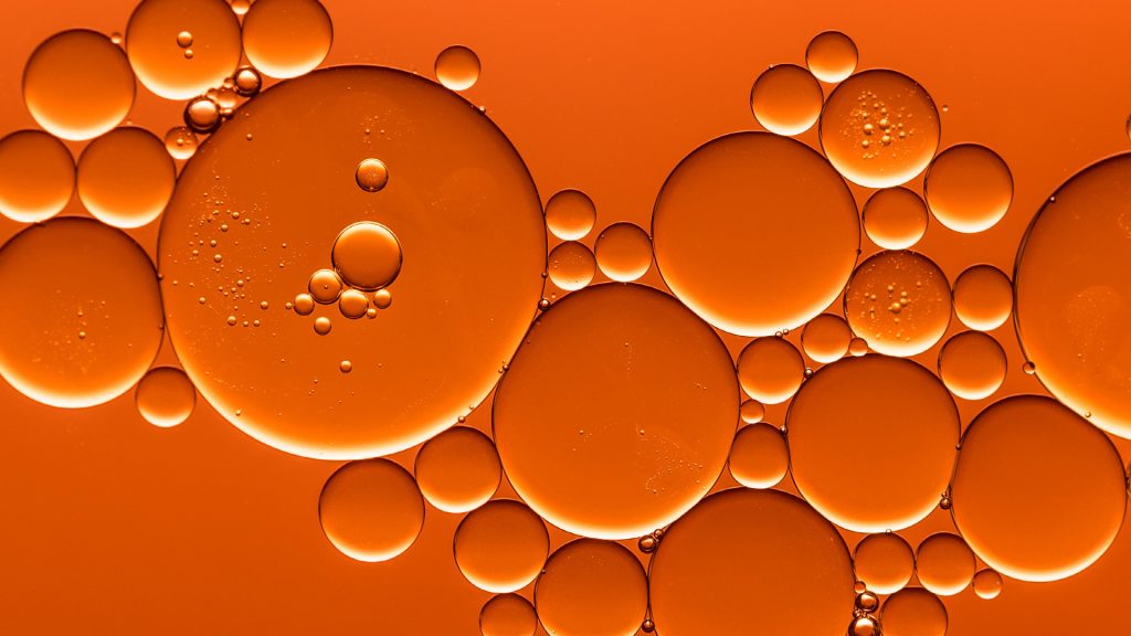 Makroaufnahme von orangefarbenen Flüssigkeitstropfen – symbolisiert den Bereich Innovative Medizintechnik und die Förderung zukunftsweisender KMU-Projekte mit PFIF.