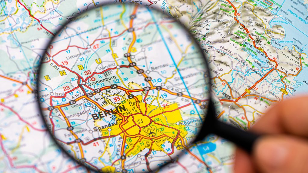Nahaufnahme einer Landkarte mit Fokus auf Berlin durch eine Lupe – steht symbolisch für die PRO FIT