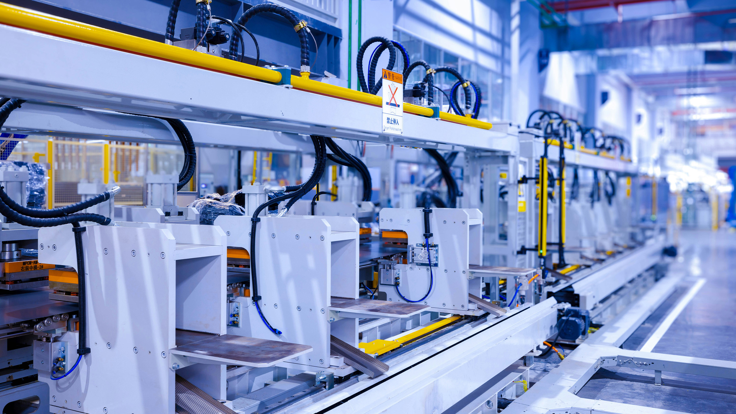 Moderne Produktionsstraße mit automatisierten Steuerungseinheiten, repräsentativ für den Einsatz der Industriellen Steuerungstechnik (Dirigent) – ISG-dirigent ermöglicht softwarebasierte Testautomatisierung von Steuerungssoftware mittels digitaler Zwillinge und fördert so die virtuelle Inbetriebnahme komplexer Maschinen in der Fertigung.