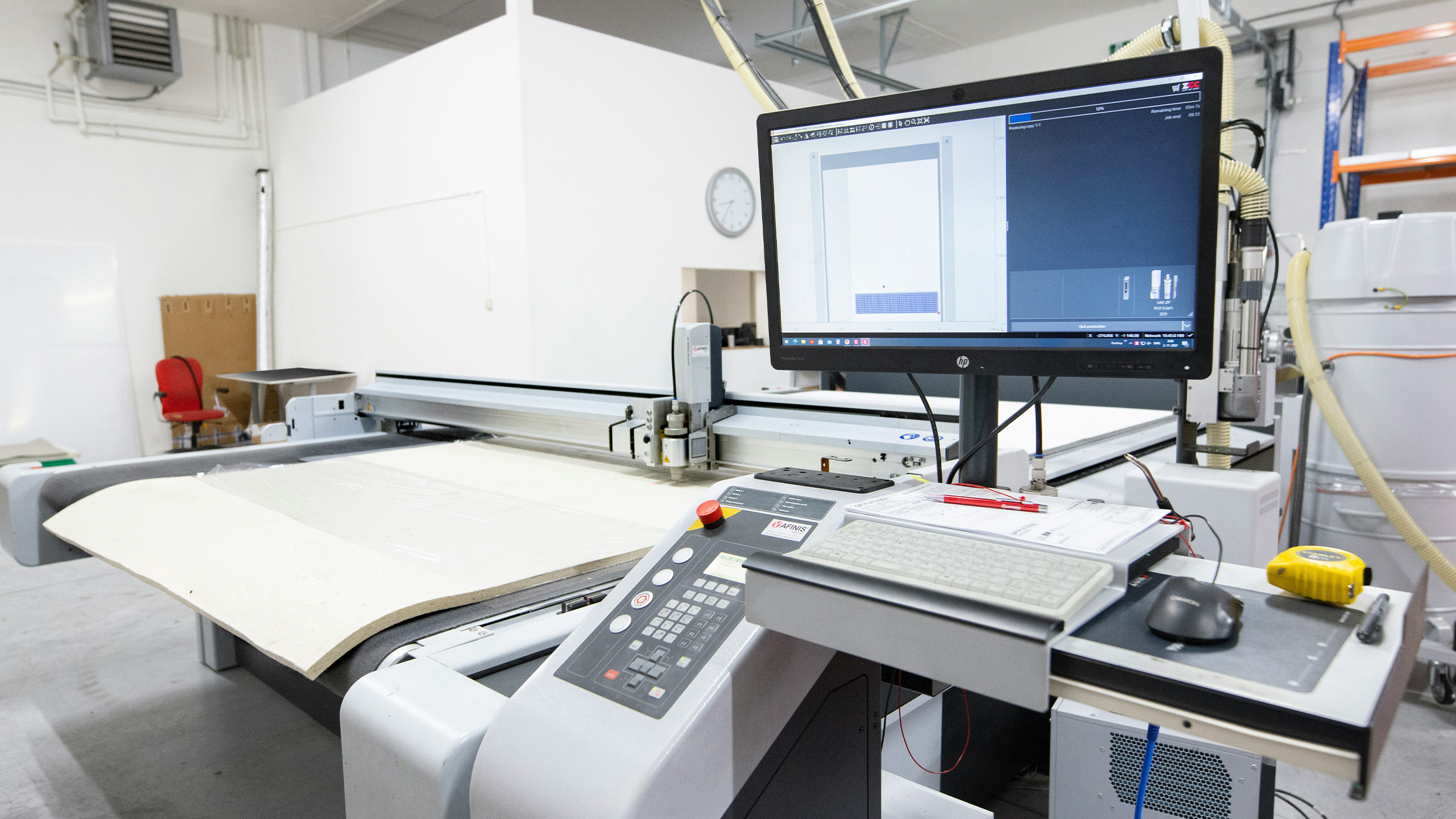 Digital gesteuerte Schneidemaschine mit Benutzeroberfläche und Monitor – stellvertretend für moderne industrielle Steuerungstechnik und digitale Zwillinge im Maschinenbau, wie sie im Projekt TwinStore von ISG Industrielle Steuerungstechnik entwickelt wurden.