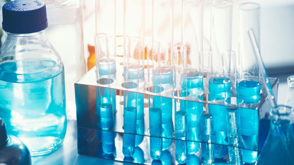 Laborumgebung mit blauen Flüssigkeiten in verschiedenen Glasgefäßen – symbolisiert die biomedizinische Forschung von T-Balance Therapeutics im Bereich Immunregulation und Zelltherapie.