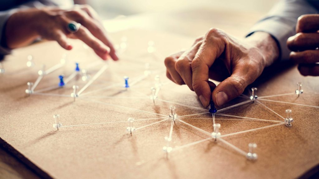 Hände die mit Fäden und Pins ein Netzwerk zeichnen als Symbol für das zentrale Innovationsprogramm Mittelstand (ZIM)