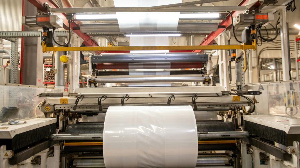 Industrielle Extrusionsanlage mit laufender Folienproduktion, bei der Mess- und Prüftechnik von Göttfert zur Qualitätsüberwachung eingesetzt werden kann.