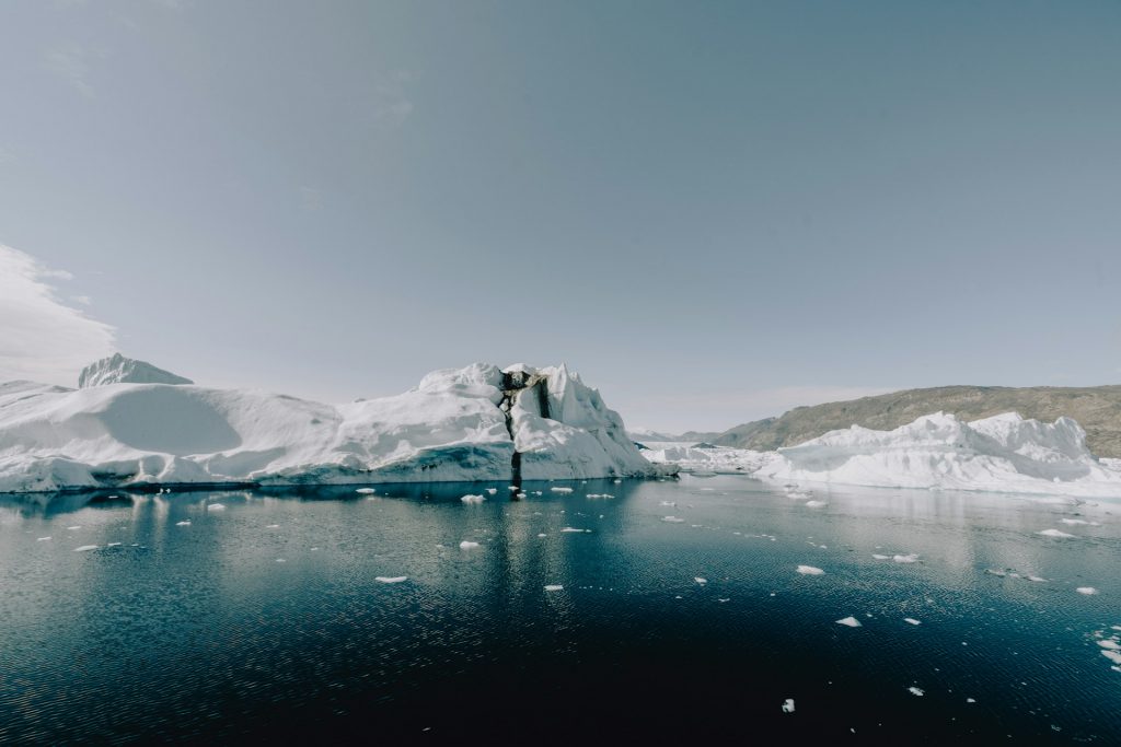 Großer Eisberg in arktischer Meereslandschaft mit schmelzendem Eis und dunklem Wasser als Symbol für Klimawandel und unternehmerische Klimaziele gemäß dem SBTi Corporate Net-Zero Standard.