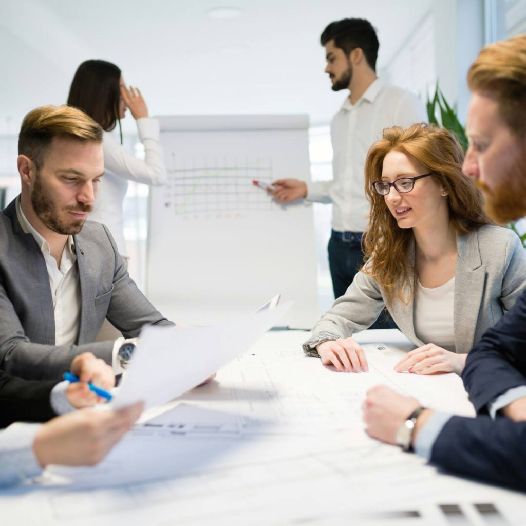 Mehrere Personen sitzen in einem Meeting als Symbol für die Fördermittelberatung zur Forschungszulage durch PFIF Partner für Innovation & Förderung.